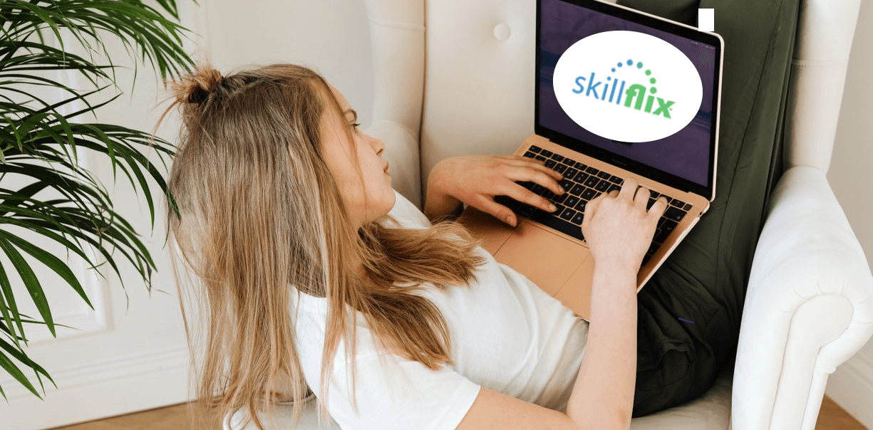 A young woman sitting in an armchair with a laptop showing the SkillFlix logo